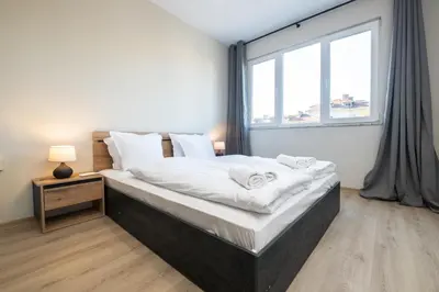 a bedroom with a large bed with a large window at Panoramic View Cozy 1BR Apartment in Plovdiv