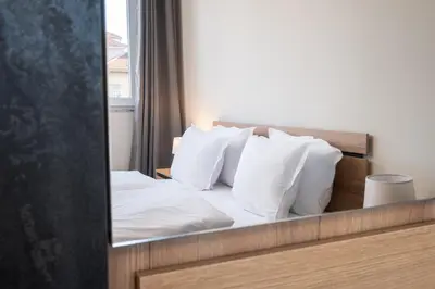 a reflection of a bed with white pillows in a mirror at Panoramic View Cozy 1BR Apartment in Plovdiv