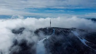 a view of a hill in the clouds with a lighthouse at Green Line Studio Appartment Pamporovo in Pamporovo