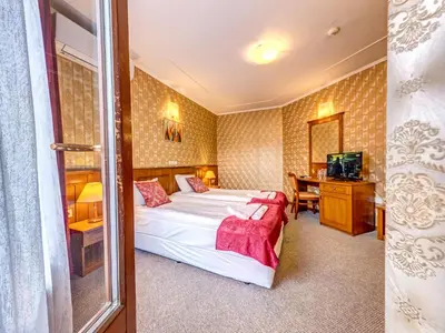 a hotel room with a bed and a desk at Хотел Елит Релакс in Devin