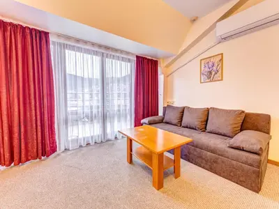 a living room with a couch and a table at Хотел Елит Релакс in Devin