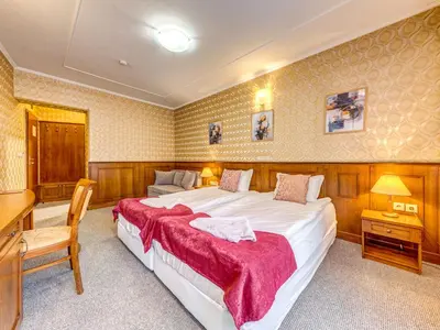 a bedroom with a large bed and a desk at Хотел Елит Релакс in Devin