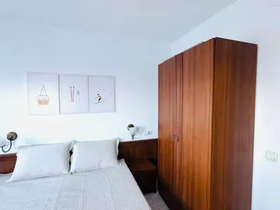 a bedroom with a bed and a wooden cabinet at Bansko 3 Ski To Door Apartment in Bansko