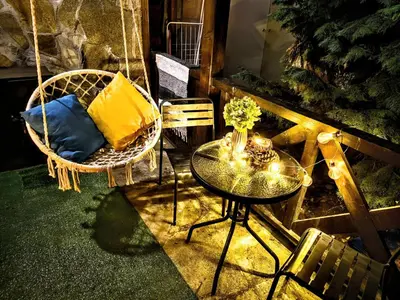 a room with a table and a chair and a table and a swing at Superior studio with terrace in 4star Green Life Bansko in Bansko