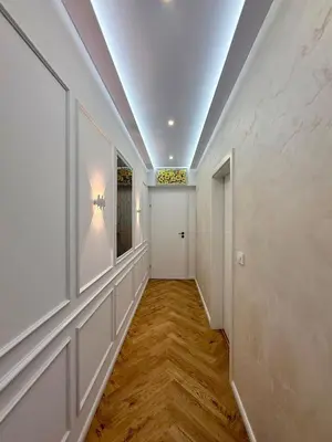 a hallway with white walls and wood floors and a door at Apartment Juliet in Sofia