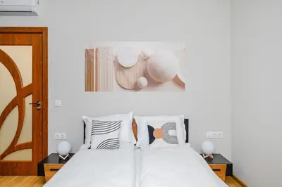 a bedroom with a bed with white sheets and pillows at Modern Stay with Balcony in Sofia
