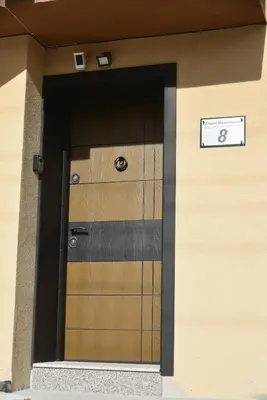 a building with a wooden door with a sign on it at C&A Apartment in Gotse Delchev