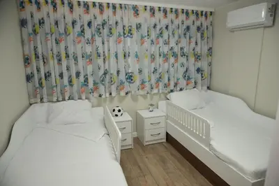 a bedroom with two beds and a crib at C&A Apartment in Gotse Delchev