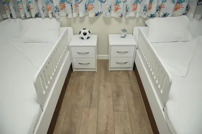 a bedroom with two twin beds with white bedsskirts at C&A Apartment in Gotse Delchev