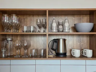 a shelf with wine glasses and a coffee pot on it at EDEL View! 1BR Ap with Top Mountain View in Bansko in Bansko