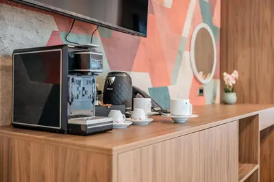 a microwave sitting on top of a counter with cups at NOVITA Hotel Sofia FREE UNDERGROUND PARKING in Sofia