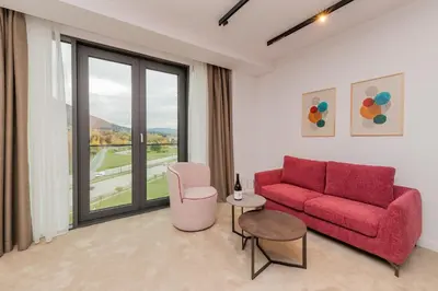 a living room with a red couch and a window at NOVITA Hotel Sofia FREE UNDERGROUND PARKING in Sofia