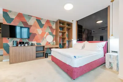a bedroom with a large bed and a tv at NOVITA Hotel Sofia FREE UNDERGROUND PARKING in Sofia
