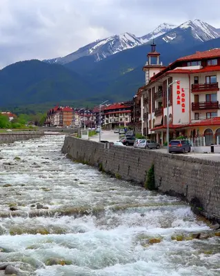a river in a town with mountains in the background at Lux Apartment B11 in Bansko