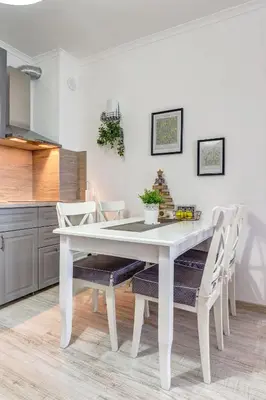 a white dining room table and chairs in a kitchen at Sweet Home Family Lodge at Grand Monastery in Smolyan