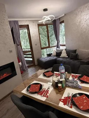 a living room with a table and a couch at Dream Apart - Iceberg in Pamporovo
