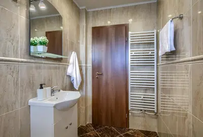 a bathroom with a sink and a wooden door at Rila North Samokov in Samokov