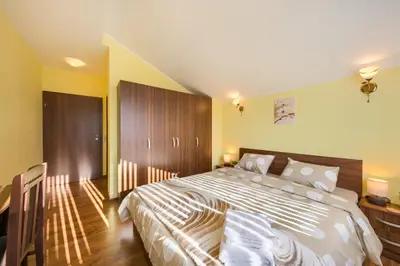 a bedroom with a large bed and a desk at Rila North Samokov in Samokov