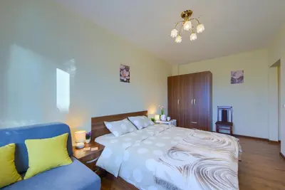 a bedroom with a large bed and a blue couch at Rila North Samokov in Samokov
