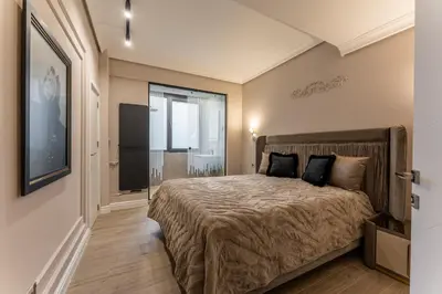 a bedroom with a bed and a large window at Exclusive Luxury Central Apartment in Sofia
