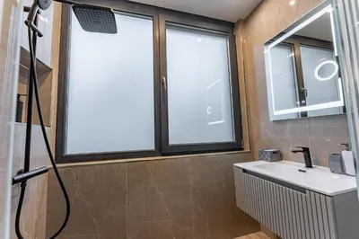a bathroom with a sink and two windows at Exclusive Luxury Central Apartment in Sofia