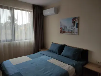 a bedroom with a bed with blue sheets and a window at Апартамент за гости НИКОЛОВА in Plovdiv