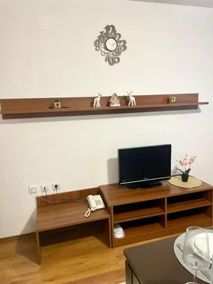 a living room with a flat screen tv on a shelf at The Cozy Spot by the Ski Lift Gondola by SI Stay in Bansko