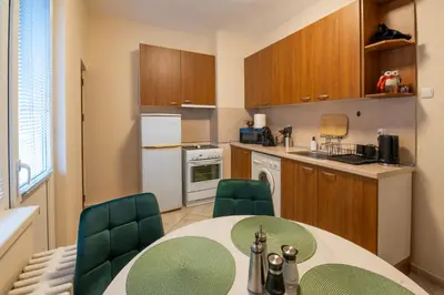 a kitchen with a table and chairs in a kitchen at NDK Garden at Vitosha Blvd Absolutely Top Center with Free Parking in Sofia