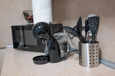 a kitchen counter with utensils inainers on a counter top at NDK Garden at Vitosha Blvd Absolutely Top Center with Free Parking in Sofia