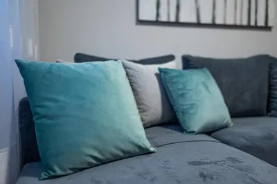 a gray couch with two blue pillows on it at NDK Garden at Vitosha Blvd Absolutely Top Center with Free Parking in Sofia