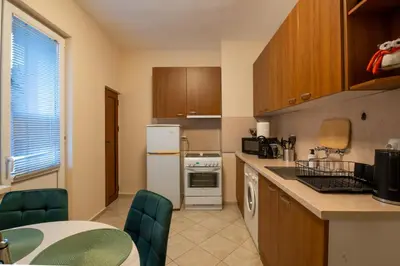a kitchen with wooden cabinets and a counter top at NDK Garden at Vitosha Blvd Absolutely Top Center with Free Parking in Sofia