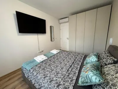 a bedroom with a bed and a flat screen tv at Harmony Apartment by 7th Sence in Sofia