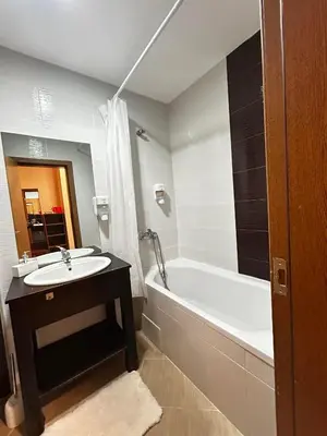 a bathroom with a white tub and a sink and a bath tub at Green Point Apartment A18 in Pamporovo
