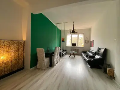 a living room with a couch and a green wall at Comedy Theatre apartments in Sofia