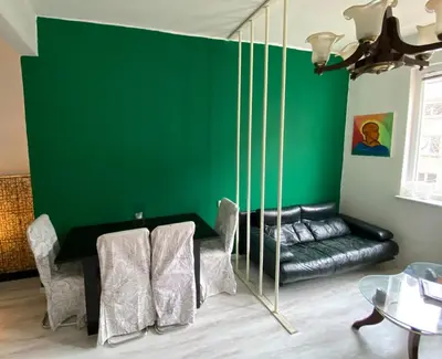 a living room with a green wall and a couch at Comedy Theatre apartments in Sofia