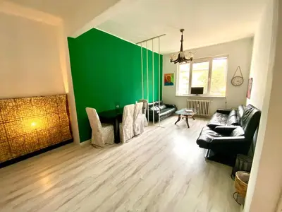 a living room with a green wall and a couch at Comedy Theatre apartments in Sofia