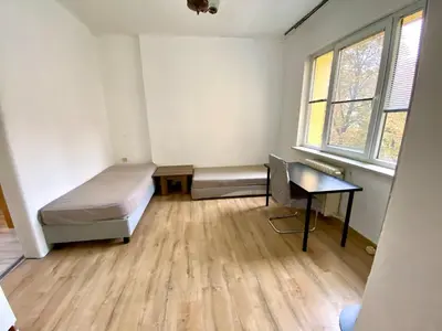 a room with a bed and a desk and windows at Comedy Theatre apartments in Sofia