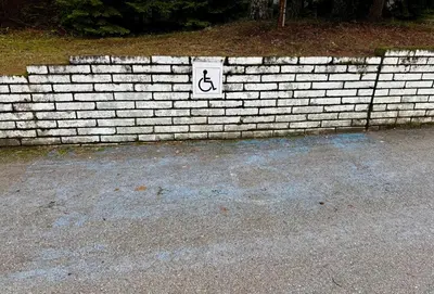 a sign on a brick wall with a handicap sign at Apartment Alex in Borovets