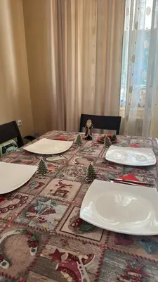 a table with plates and christmas trees on it at Ava Apartment Pamporovo in Pamporovo