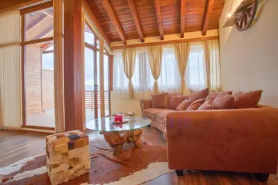 a living room with a couch and a table at Stylish Two-Level Apartment in Bansko by Flat Mаnаger in Blagoevgrad