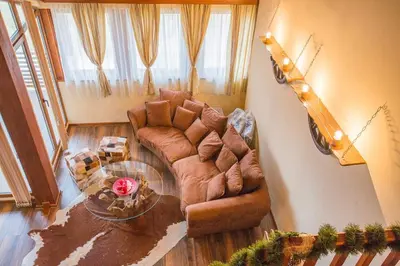 a living room with a couch and a table at Stylish Two-Level Apartment in Bansko by Flat Mаnаger in Blagoevgrad