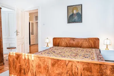 a bed with a wooden headboard in a bedroom at Big Apartment in Center Sofia - 2 BD - Fireplace in Sofia