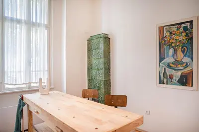 a dining room with a wooden table and a painting at Big Apartment in Center Sofia - 2 BD - Fireplace in Sofia