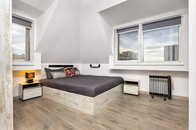 a bedroom with a bed and two windows at Top-Floor Flat with Balcony by Flat Manаger in Plovdiv
