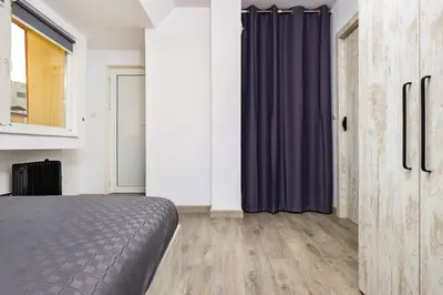 a bedroom with a bed and a purple curtain at Top-Floor Flat with Balcony by Flat Manаger in Plovdiv