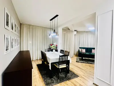 a dining room and living room with a table and chairs at Urban Glow Apartment near Metro Station in Sofia