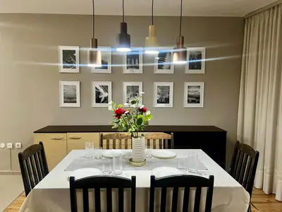 a dining room with a table with a vase of flowers at Urban Glow Apartment near Metro Station in Sofia