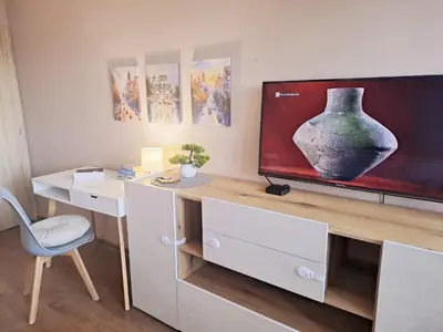 a room with a desk with a vase on a tv at LevskiG Family Flat 10 min from Sofia Airport and city center in Sofia
