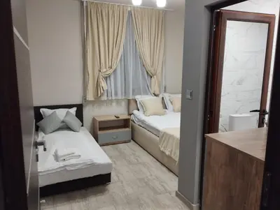 a small bedroom with two beds and a window at Странската изба град Калофер in Kalofer