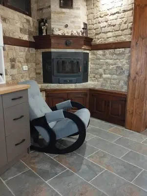 a chair in a kitchen with a stone wall at Странската изба град Калофер in Kalofer